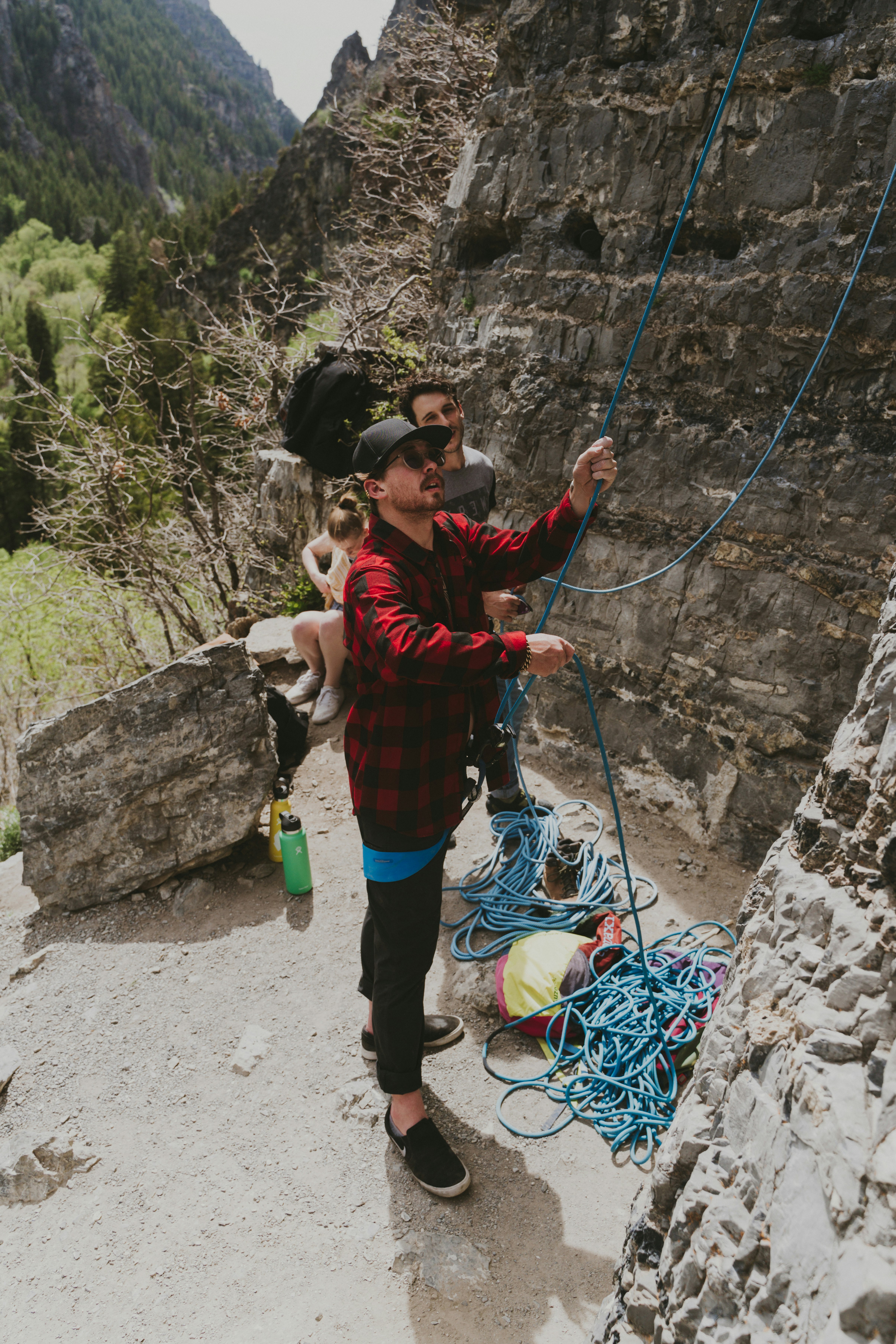 girl in red and black jacket climbing on rock during daytime